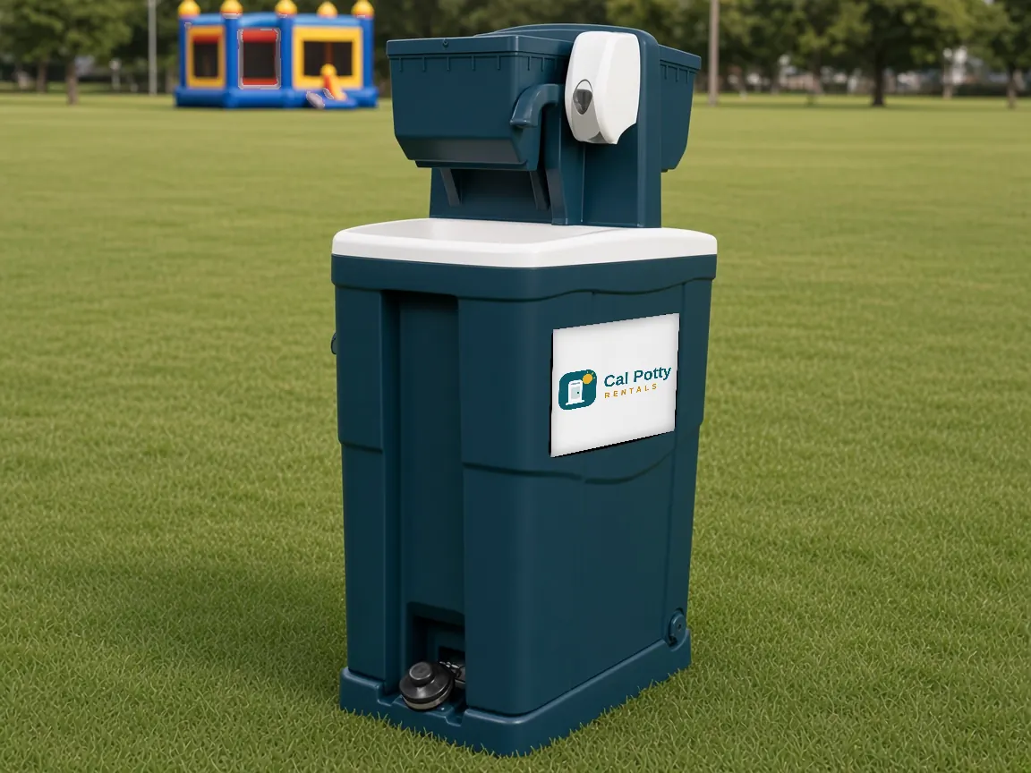 A teal handwashing station on a lawn with a bounce house in the background